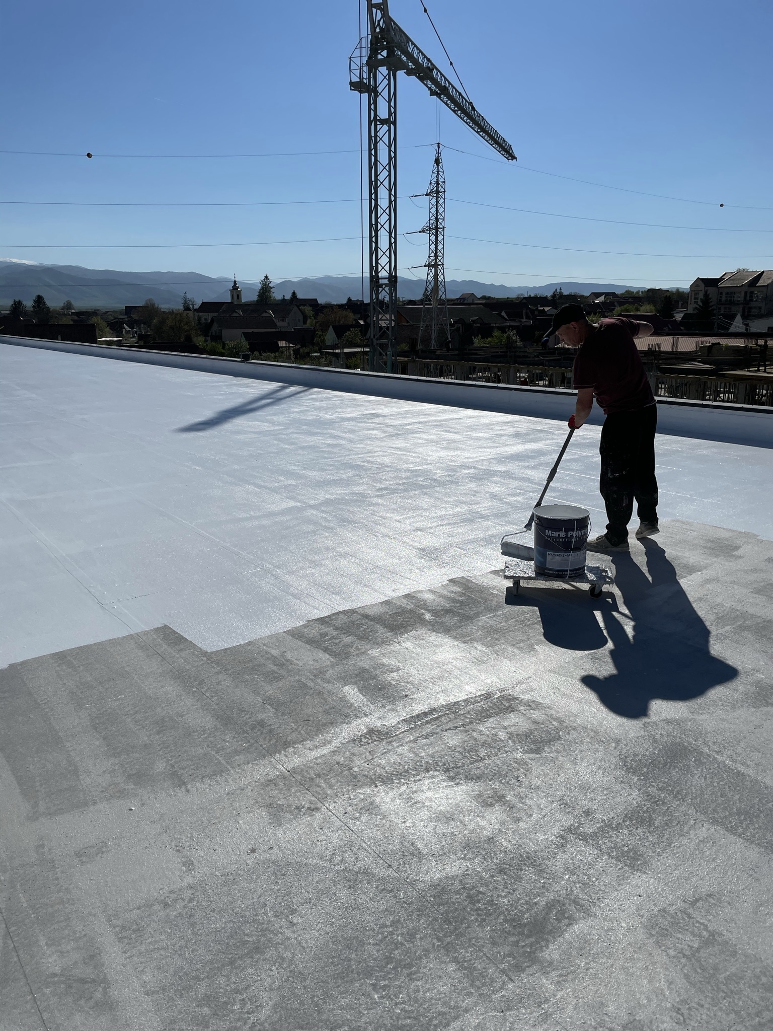 Aquazid team applying polyurethane liquid waterproofing on a roof